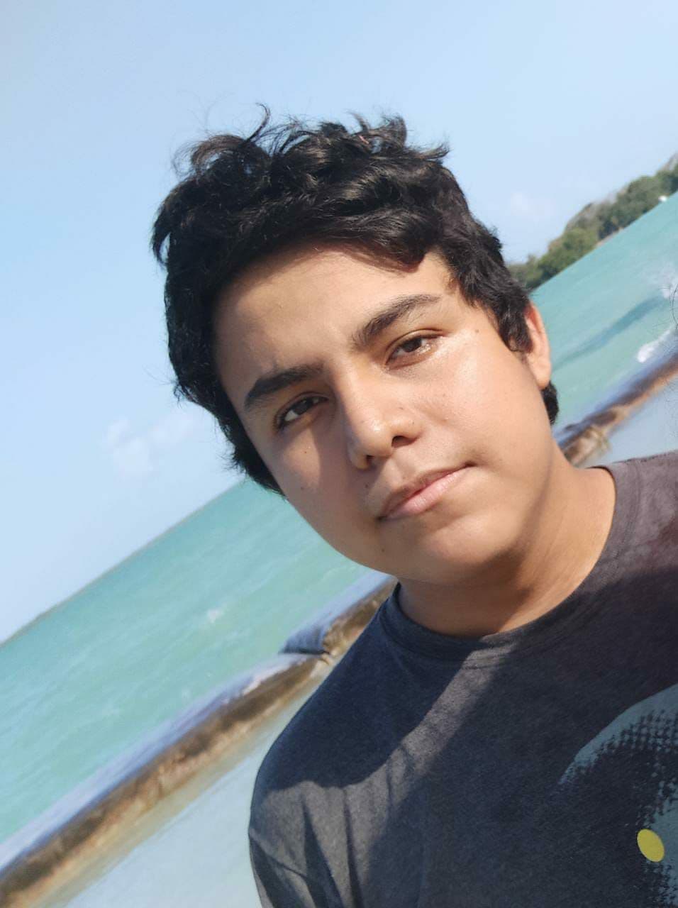 Persona en la playa, mirando a la cámara.